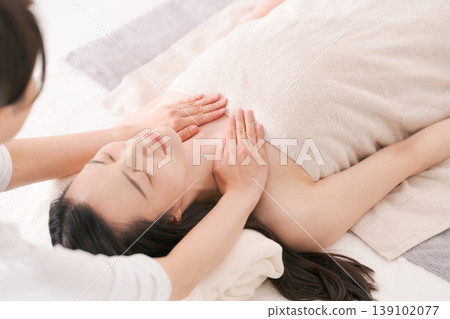 A woman who receives a treatment at an esthetic salon A woman who receives a treatment at an esthetic salon 139102077
