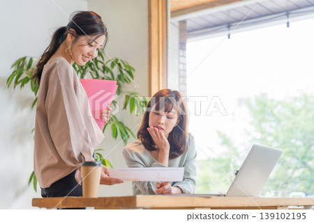 兩個年輕婦女有辦公室的形象 兩個年輕婦女有辦公室的形象 139102195