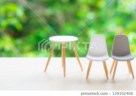 Chairs and table against a natural green background Chairs and table against a natural green background 139102408