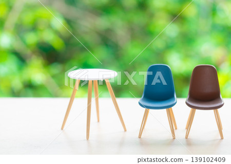 Chairs and table against a natural green background Chairs and table against a natural green background 139102409