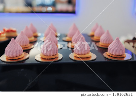 Pink Meringue Tarts Arranged On Tray, Artisan Bakery Display Showcasing Delicate Swirled Meringue Nests Atop Crisp Round Bases, Soft Pastel Lighting, Shallow Depth Of Field, Modern 139102631