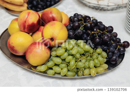 Assorted Ripe Peaches And Grapes Presented For Stylish Brunch Setting. Vibrant Seasonal Fruits Including Peaches And Grapes Beautifully Arranged On Elegant Silver Plate For Brunch Assorted Ripe Peaches And Grapes Presented For Stylish Brunch Setting. Vibrant Seasonal Fruits Including Peaches And Grapes Beautifully Arranged On Elegant Silver Plate For Brunch 139102706