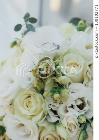 Wedding Rings Resting On Cream Roses In Soft Macro Focus, Delicate Petals And Metallic Bands Create Intimate Symbolic Detail Shallow Depth Of Field Highlights Texture Of Blooms And Sparkle Wedding Rings Resting On Cream Roses In Soft Macro Focus, Delicate Petals And Metallic Bands Create Intimate Symbolic Detail Shallow Depth Of Field Highlights Texture Of Blooms And Sparkle 139102771