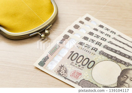 桌上放著一張10,000日圓鈔票和一個錢包。 139104117