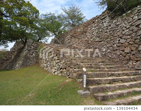 The historic stone steps leading to the main keep of Sumoto Castle on Awaji Island, and the sturdy stone walls built in the rough-hewn style. The historic stone steps leading to the main keep of Sumoto Castle on Awaji Island, and the sturdy stone walls built in the rough-hewn style. 139104434