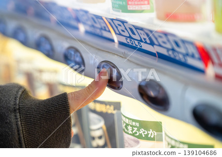 一位女士在自動販賣機購買果汁時的雙手。 一位女士在自動販賣機購買果汁時的雙手。 139104686