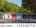 "A colorful warehouse surrounded by greenery and a tranquil facility landscape" 139104759