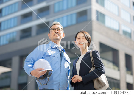 一名男子和一名身穿工作服的女商人 一名男子和一名身穿工作服的女商人 139104781