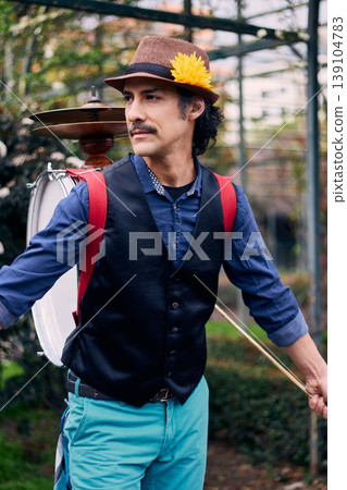 Cheerful Latin American man posing with a bass drum on his back, Chilean chinchinero, street musician who plays the bass drum and cymbals and dances in the streets, Chilean cultural tradition, Cheerful Latin American man posing with a bass drum on his back, Chilean chinchinero, street musician who plays the bass drum and cymbals and dances in the streets, Chilean cultural tradition, 139104783