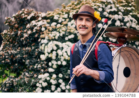 Cheerful Latin American man posing with a bass drum on his back, Chilean chinchinero, street musician who plays the bass drum and cymbals and dances in the streets, Chilean cultural tradition 139104788