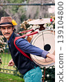 Cheerful Latin American man posing with a bass drum on his back, Chilean chinchinero, street musician who plays the bass drum and cymbals and dances in the streets, Chilean cultural tradition 139104800