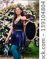 Beautiful dark-haired Latina woman posing with a drum and cymbals on her back, full of joy, a chinchinera, a street musician who dances and plays her drum in the streets. Chilean heritage 139104804