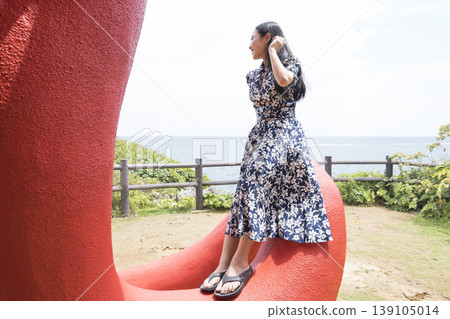 A woman sitting on an octopus tentacle at the octopus park on Kurima Island. 139105014