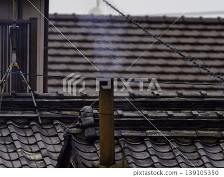 昭和時代的懷舊景象,炊煙從屋頂的煙囪中裊裊升起。 昭和時代的懷舊景象,炊煙從屋頂的煙囪中裊裊升起。 139105350