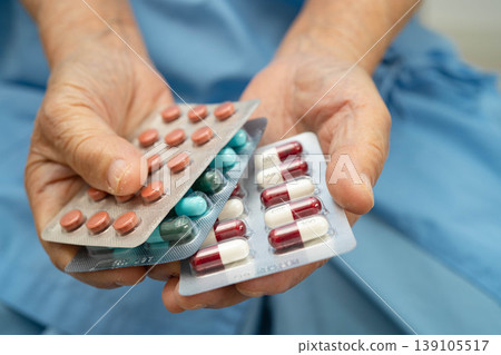 Asian elderly woman holding pill drug in hand, strong healthy medical. Asian elderly woman holding pill drug in hand, strong healthy medical. 139105517