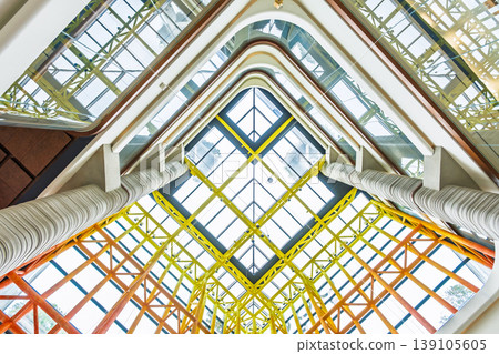 現代建築,採用塗漆鋼桁架和玻璃天窗,從室內高處拍攝,呈現幾何對稱的構圖。 現代建築,採用塗漆鋼桁架和玻璃天窗,從室內高處拍攝,呈現幾何對稱的構圖。 139105605