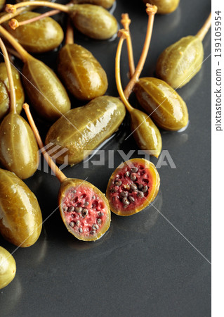 Canned capers on a black plate. Canned capers on a black plate. 139105954