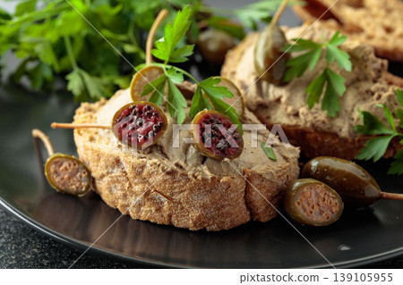 Bread with liver pate, capers, and fresh parsley. Bread with liver pate, capers, and fresh parsley. 139105955