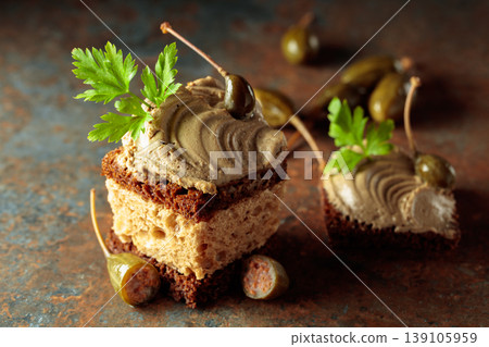 Bread with pate, capers, and fresh parsley. 139105959