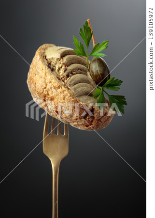 Bread with liver pate, capers, and fresh parsley on a fork. Bread with liver pate, capers, and fresh parsley on a fork. 139105972