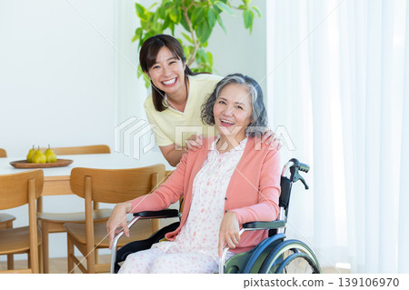 Caregiver supporting a woman in a wheelchair 139106970