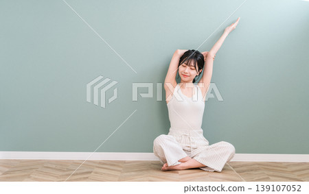 Asian woman stretching and taking a deep breath at home (hair removal, yoga) Asian woman stretching and taking a deep breath at home (hair removal, yoga) 139107052