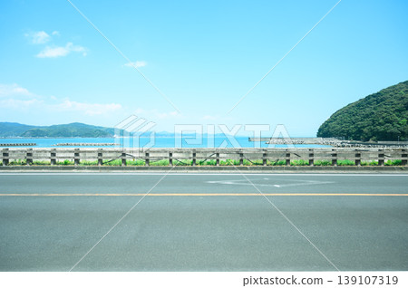 A seaside road that evokes a sense of wanderlust, with a striking contrast between the horizon and the asphalt. A seaside road that evokes a sense of wanderlust, with a striking contrast between the horizon and the asphalt. 139107319