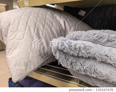 Grey Quilted Pillow and Soft Faux Fur Blanket on Retail Display Shelf Grey Quilted Pillow and Soft Faux Fur Blanket on Retail Display Shelf 139107476