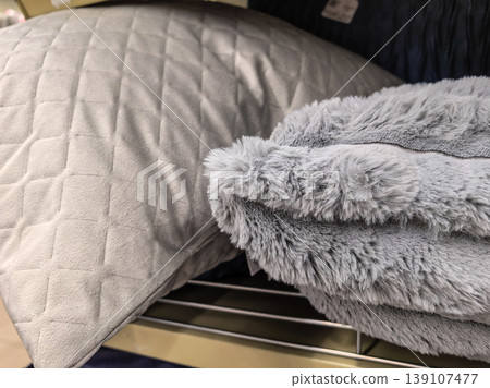 Soft gray pillow and fluffy blanket on store shelf Soft gray pillow and fluffy blanket on store shelf 139107477