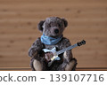 A teddy bear holding a guitar; a dark brown bear with a brown guitar. 139107716