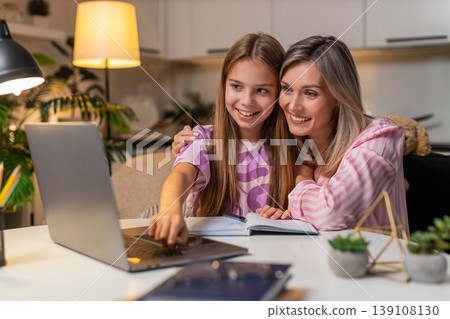 Mother and daughter send homework online on laptop child presses submit mother smiles closes laptop Mother and daughter send homework online on laptop child presses submit mother smiles closes laptop 139108130