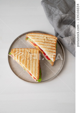 Club sandwich with ham, cheese, tomatoes, lettuce, cucumber on plate on a white background 139108834