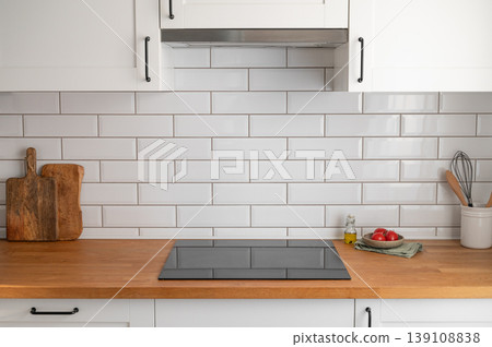Modern kitchen wooden countertop with stove and tiled wall background. Modern kitchen wooden countertop with stove and tiled wall background. 139108838