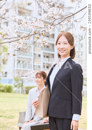 A young woman, a new employee, walking under cherry blossoms; a smiling job seeker in a spring recruitment suit; an image of an entrance ceremony. A young woman, a new employee, walking under cherry blossoms; a smiling job seeker in a spring recruitment suit; an image of an entrance ceremony. 139109650