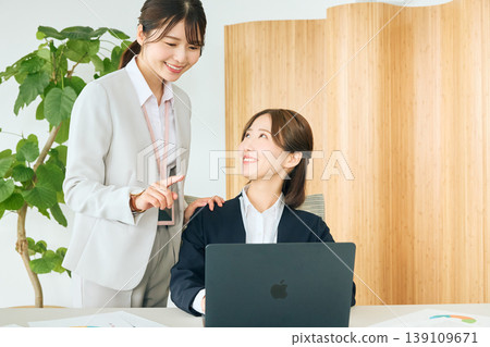 兩位年輕的日本女商務人士,一位是資深同事,一位是初級同事,正在辦公室開會,她們面前都放著筆記型電腦。 兩位年輕的日本女商務人士,一位是資深同事,一位是初級同事,正在辦公室開會,她們面前都放著筆記型電腦。 139109671