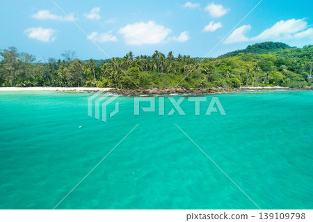 Beautiful tropical island view from the sea with crystal clear water and a rocky beach. Beautiful tropical island view from the sea with crystal clear water and a rocky beach. 139109798
