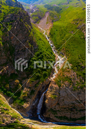 Aerial view of mountain valley with waterfall and rocky cliffs Aerial view of mountain valley with waterfall and rocky cliffs 139109915