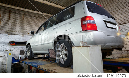 Vehicle on a lift in a garage during an afternoon service check 139110673