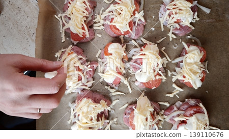 Cooking process of preparing food with cheese and toppings on a baking tray in a home kitchen Cooking process of preparing food with cheese and toppings on a baking tray in a home kitchen 139110676
