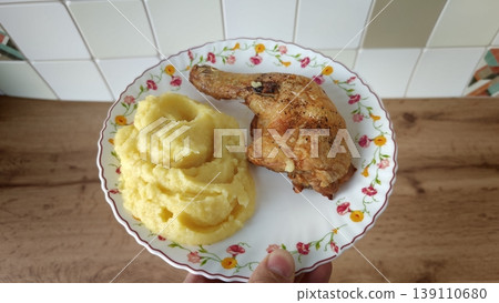 Delicious meal with chicken leg and mashed potatoes on a patterned plate 139110680
