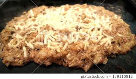 Hot and piping hot mentaiko cheese monjayaki cooked on a griddle Hot and piping hot mentaiko cheese monjayaki cooked on a griddle 139110812