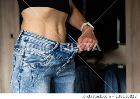 fit woman checking her flat belly visceral fat and loosing weight fit woman checking her flat belly visceral fat and loosing weight 139110828