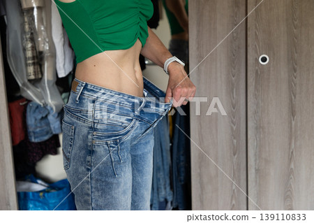 fit woman checking her flat belly visceral fat and loosing weight fit woman checking her flat belly visceral fat and loosing weight 139110833