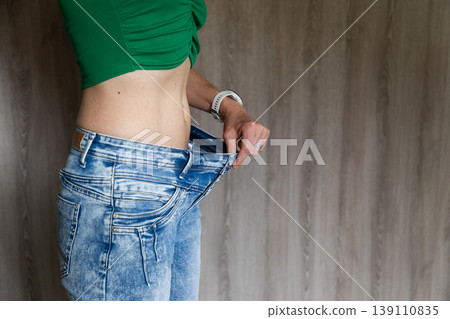 fit woman checking her flat belly visceral fat and loosing weight fit woman checking her flat belly visceral fat and loosing weight 139110835