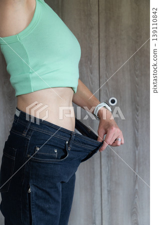 fit woman checking her flat belly visceral fat and loosing weight fit woman checking her flat belly visceral fat and loosing weight 139110842