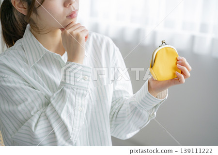 女人拿著錢包;物價高昂;省錢。 女人拿著錢包;物價高昂;省錢。 139111222