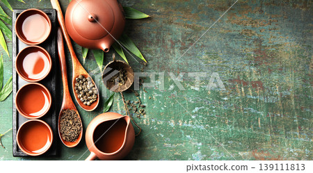 Assorted Loose Leaf Teas with Clay Teapot and Teacups on Rustic Surface 139111813