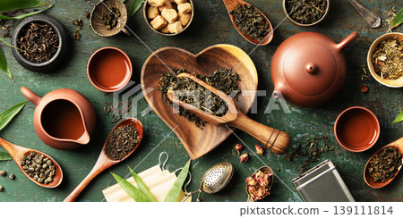 Tea Ingredients and Teaware with Heart-Shaped Bowl on Rustic Background 139111814