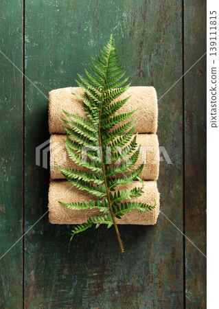 Natural Spa Towels with Green Fern Leaf on Rustic Wooden Background Natural Spa Towels with Green Fern Leaf on Rustic Wooden Background 139111815