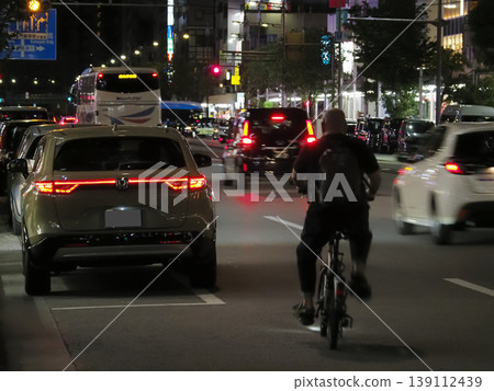 一輛自行車超過了一輛停著的汽車。 一輛自行車超過了一輛停著的汽車。 139112439